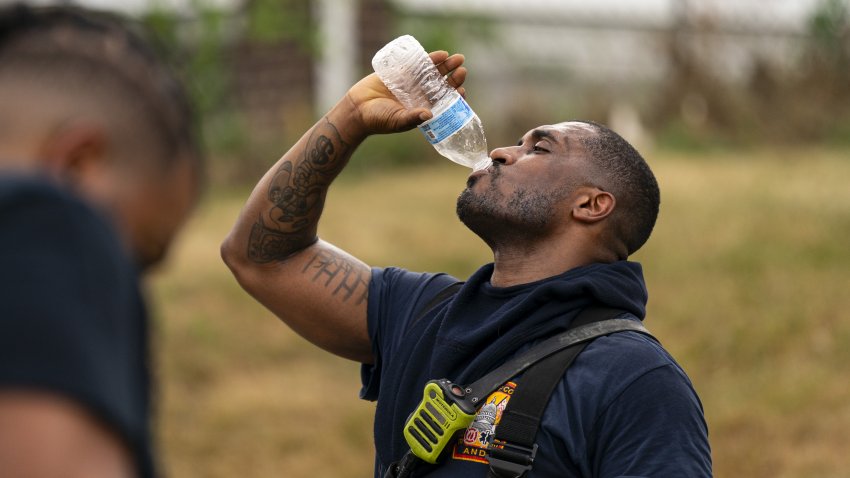 A firefighter drinks water following a kitchen fire during high temperatures in Washington, DC, US, on Sunday, June 23, 2024. New York, Washington and the middle Atlantic region will bake through another day of hot, sticky weather, pushing temperatures close to record highs before thunderstorms arrive to briefly cool things off. Photographer: Al Drago/Bloomberg via Getty Images